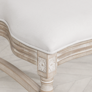 Detail of the Marlow chair's carved floret corner and limewashed turned leg