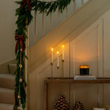 Decorative staircase with Christmas garland, candles, and pinecones.