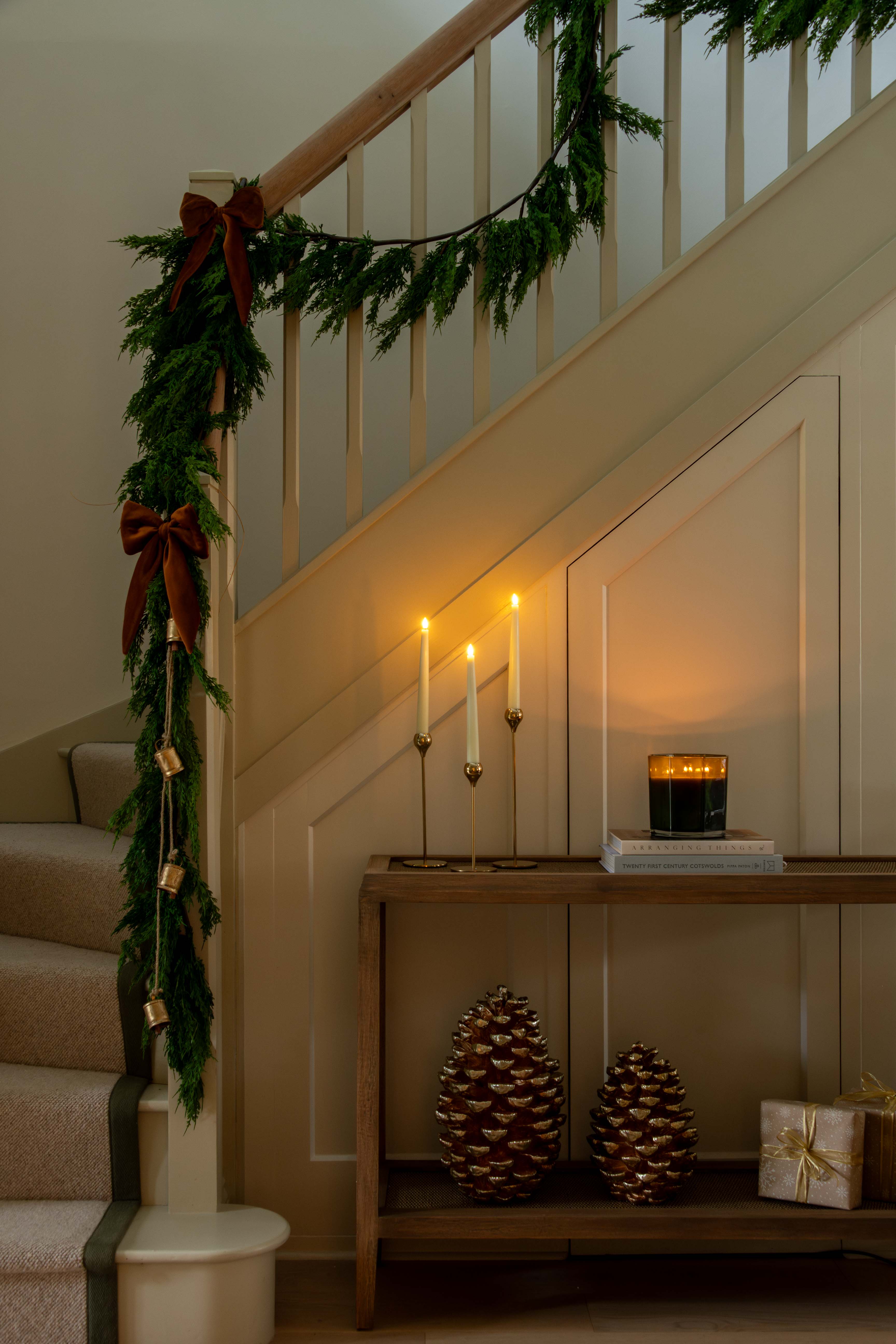 Decorative staircase with Christmas garland, candles, and pinecones.
