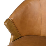 Curved backrest tan leather chair with angled wood legs