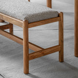 Detail of rounded acacia wood leg and grey boucle upholstered seat on a minimalist bench