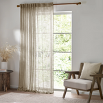Living room with a large window, beige curtains, and a wooden chair with a cushion.