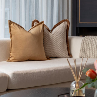 Lechlade cushion duo in beige geometric and amber velvet styled on a neutral sofa