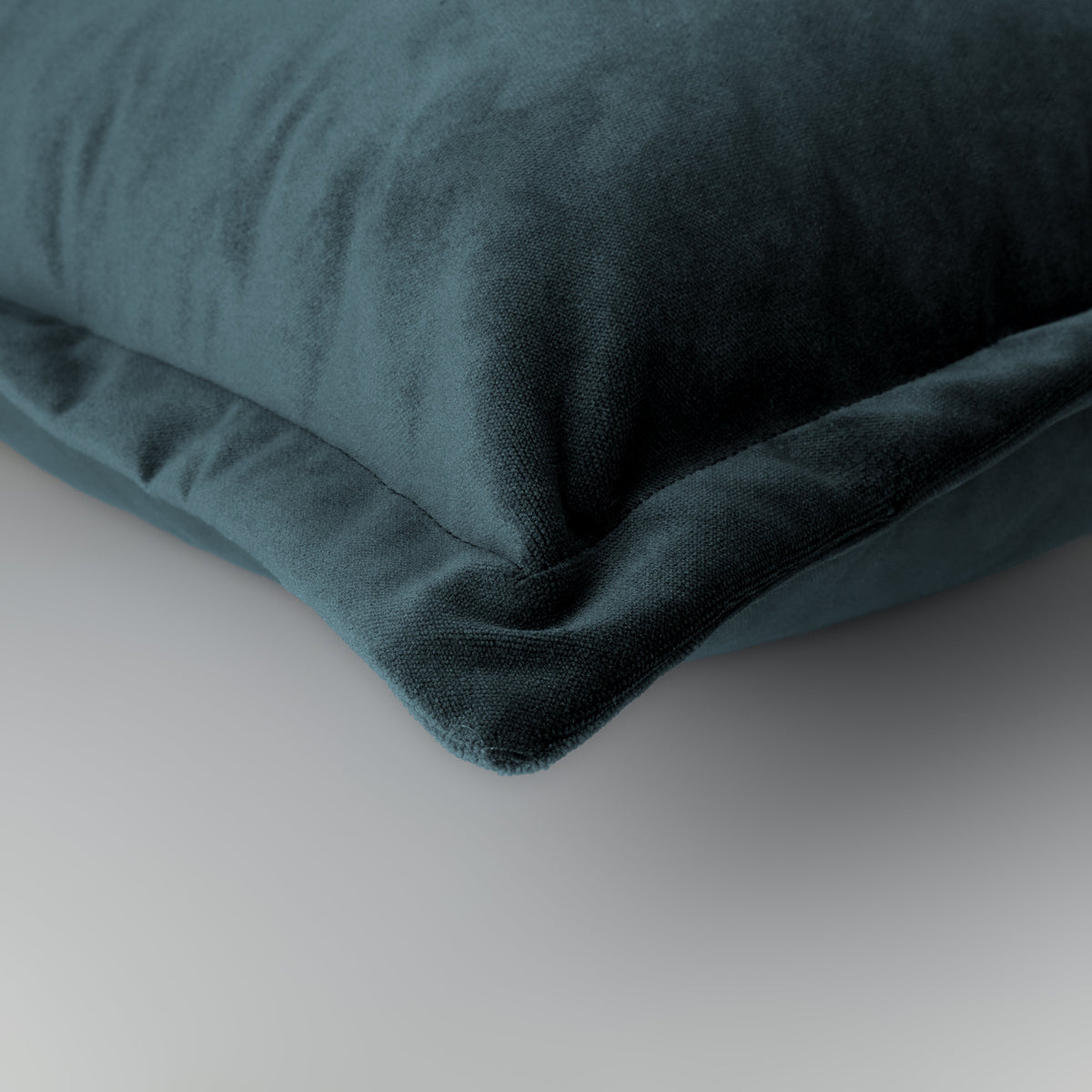 Hampnett petrol rectangle cushion with cuffed edge styled on a sofa