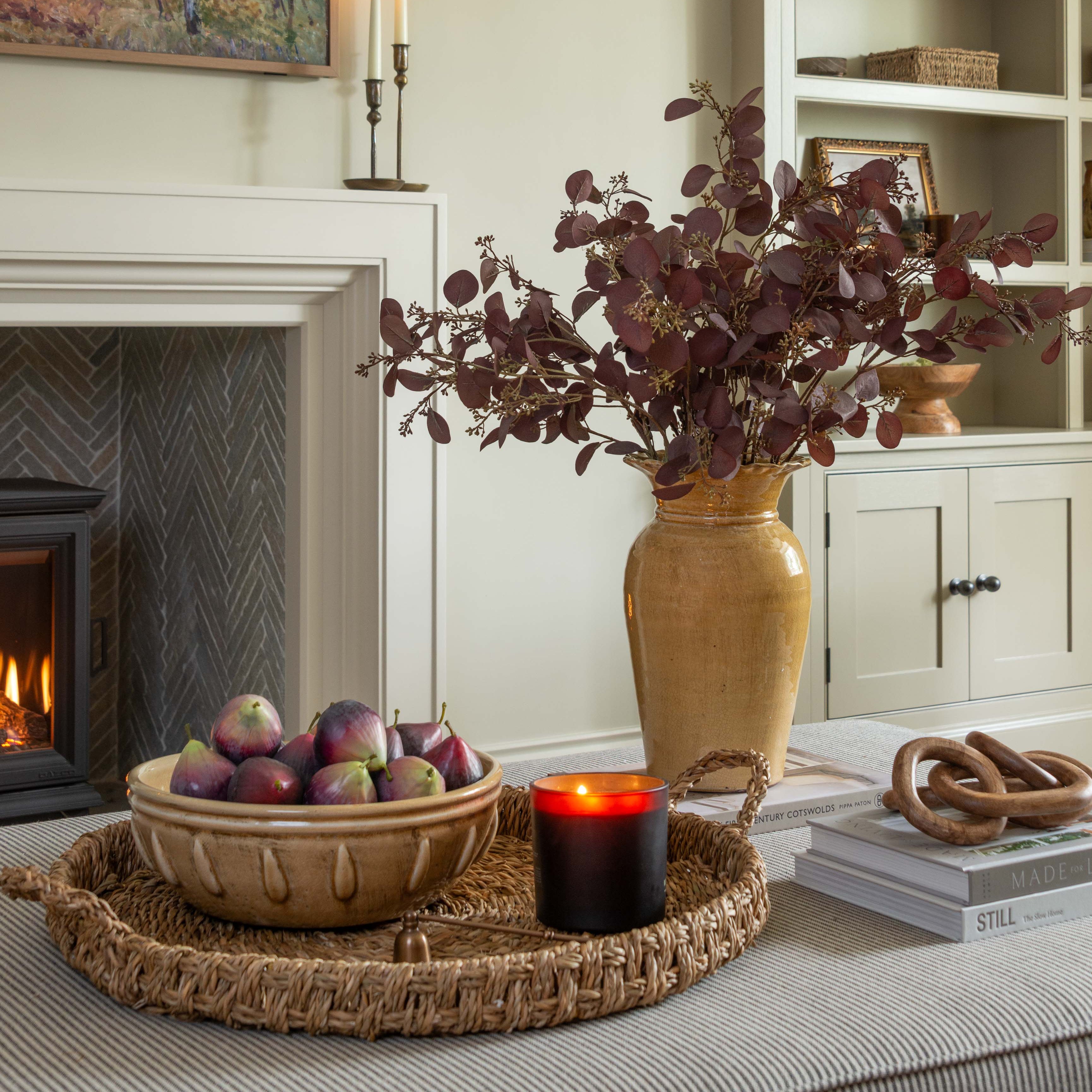 Living room with fireplace, decorative items, and a vase with flowers.