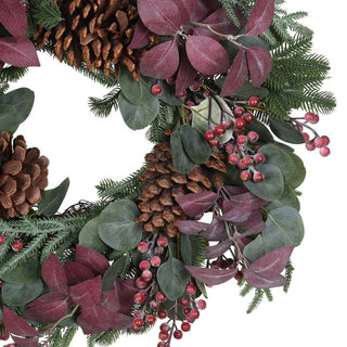 Close up of frosted red berries, plum eucalyptus and pinecones on the Savernake wreath
