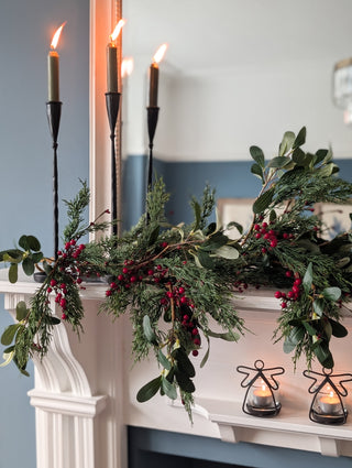 Close detail of olive leaves and red berries on the Christmas garland
