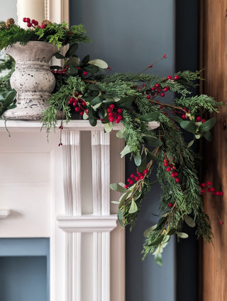 Cypress, olive leaf and red berry garland as a Christmas table centrepiece