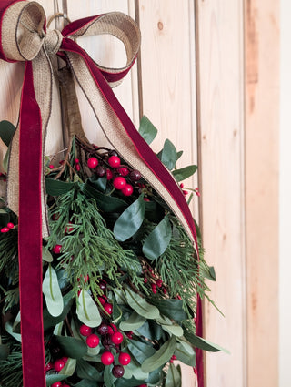 Softly layered faux olive leaves and red berries on the hanging swag