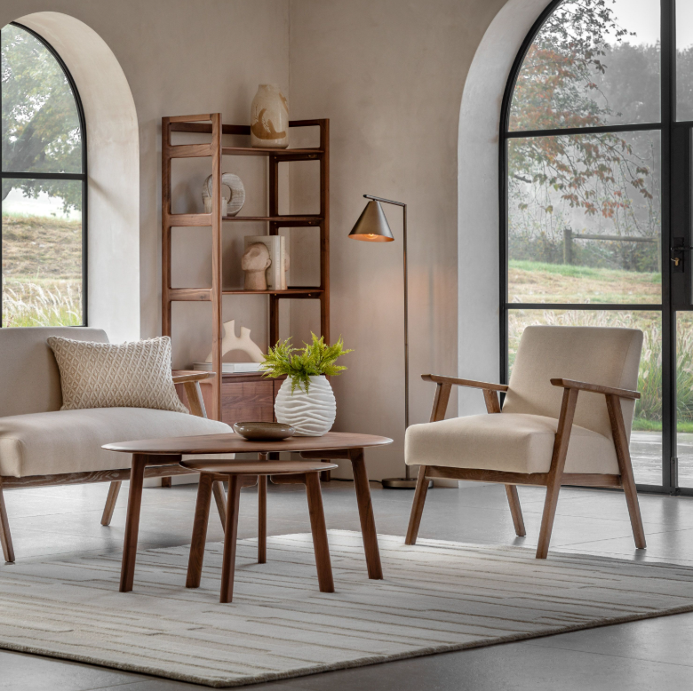Modern living room with beige sofa, armchair, and wooden coffee table.