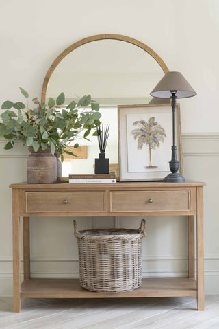 Pembury black table lamp styled on a wooden console table alongside an arched brass-framed mirror, stacked books, framed art and brown vase with foliage