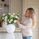 Pom Pom White Viburnum Spray. Its snowball-like floral heads and lush leaves, delicately drooping like the real thing, make for an incredibly lifelike addition to any setting. Use between 6 - 8 stems for a truly impressive impact.