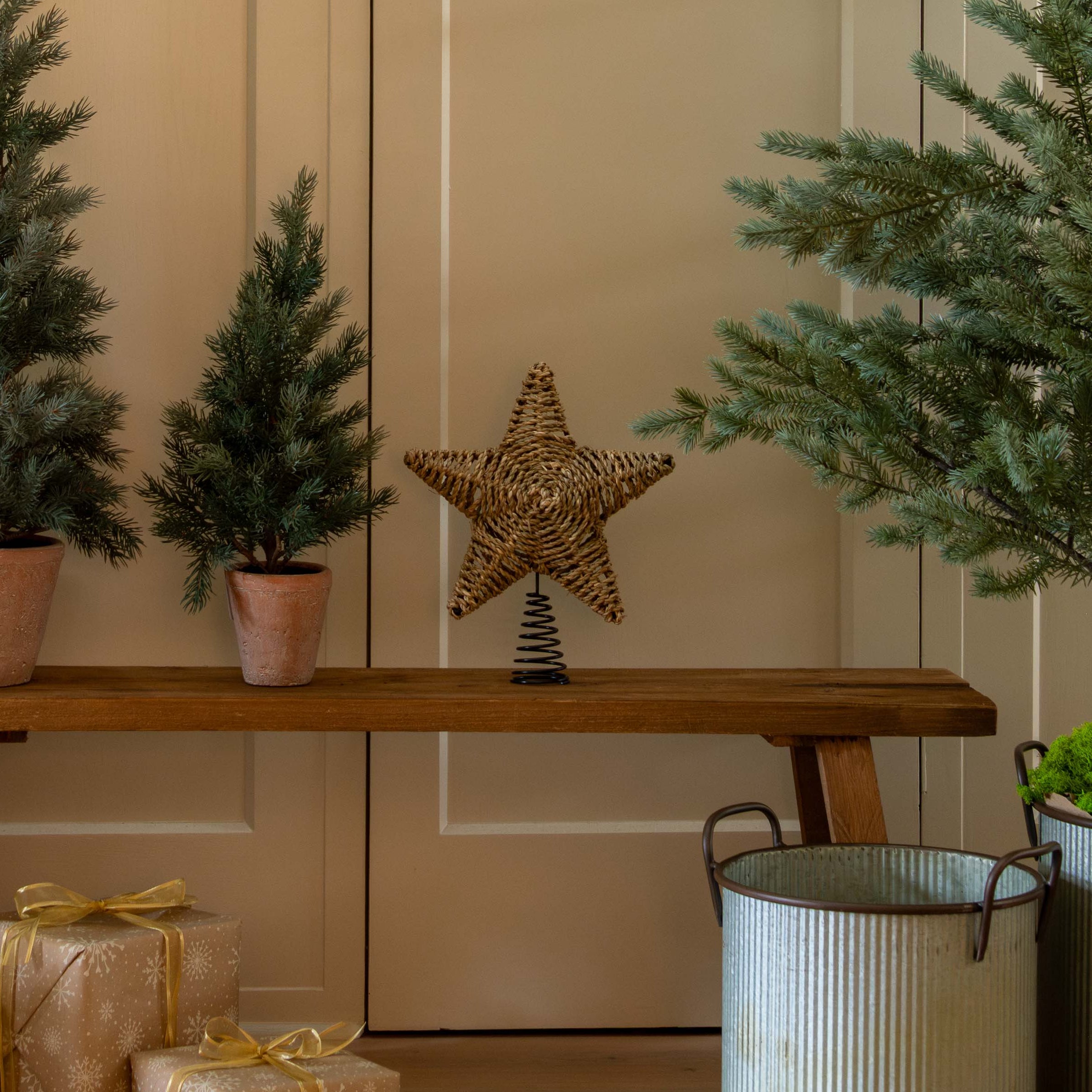 Decorative setup with Christmas trees, a star, and gift boxes in a home interior.