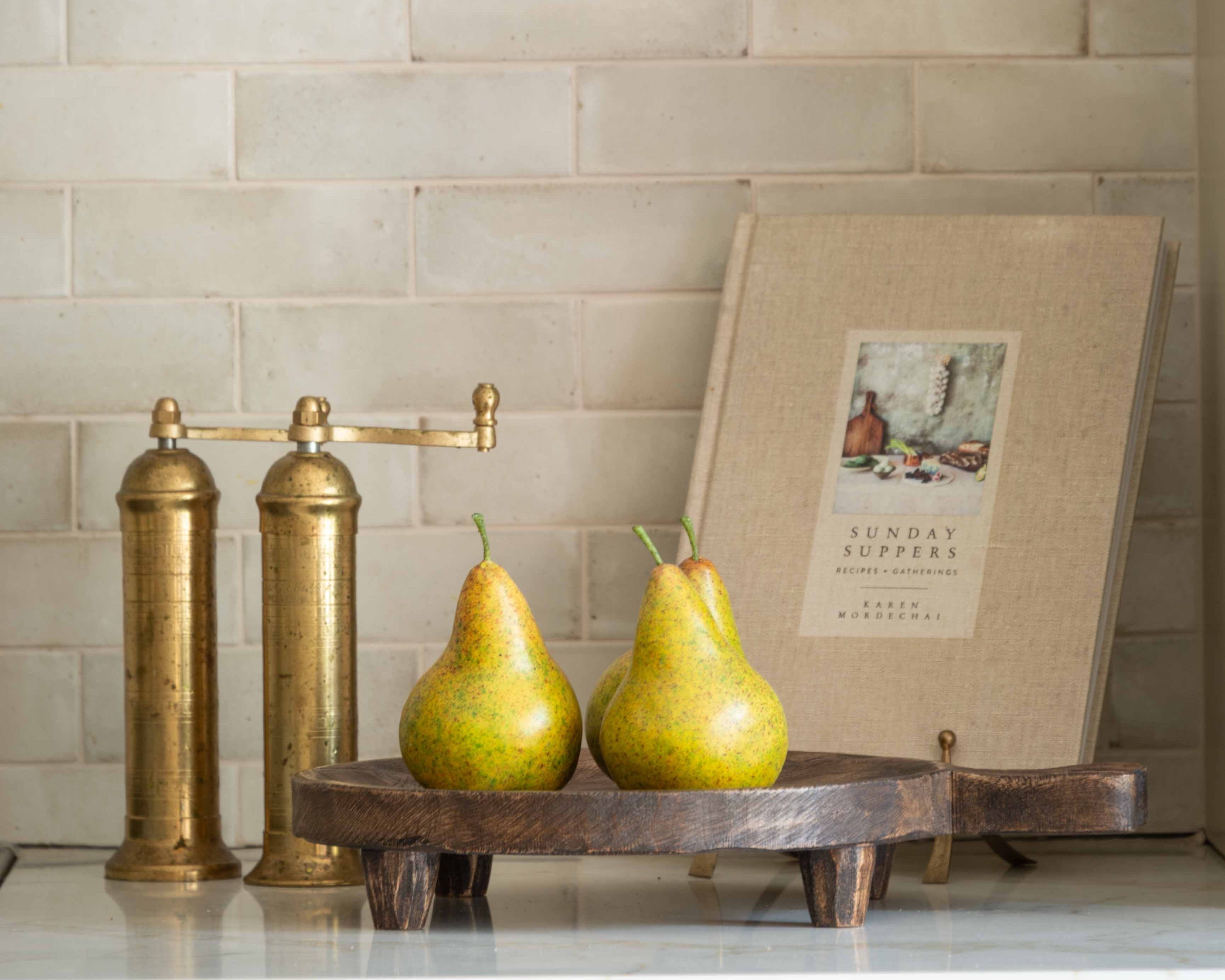 Rustic wooden footed tray styled with fresh pears on a marble countertop