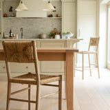 Kitchen with wooden table and chairs, light-colored cabinets, and a neutral color palette.