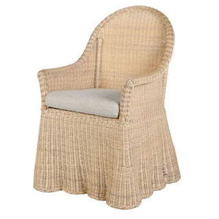 A light natural rattan dining chair with a high curved back, a light gray cushion on the seat, and a skirted base, shown against a plain white background.