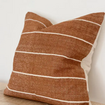 A stunning rust coloured cotton cushion with an off white stripe.