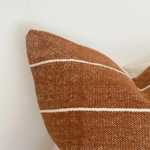 A stunning rust coloured cotton cushion with an off white stripe.
