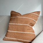 A stunning rust coloured cotton cushion with an off white stripe.