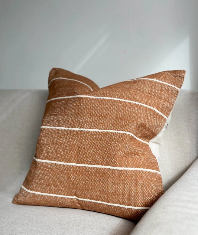 A stunning rust coloured cotton cushion with an off white stripe.
