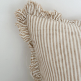 Light brown striped linen cushion cover with ruffled edges close up