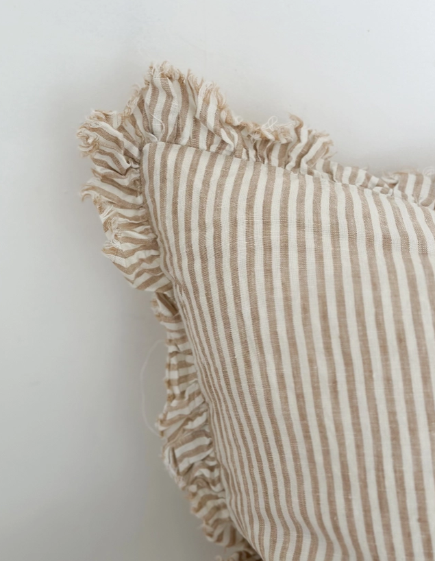 Light brown striped linen cushion cover with ruffled edges close up