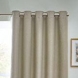 Beige curtain with metallic rings on a gray wall background