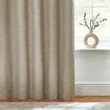 Beige curtain in a room with a vase on a windowsill