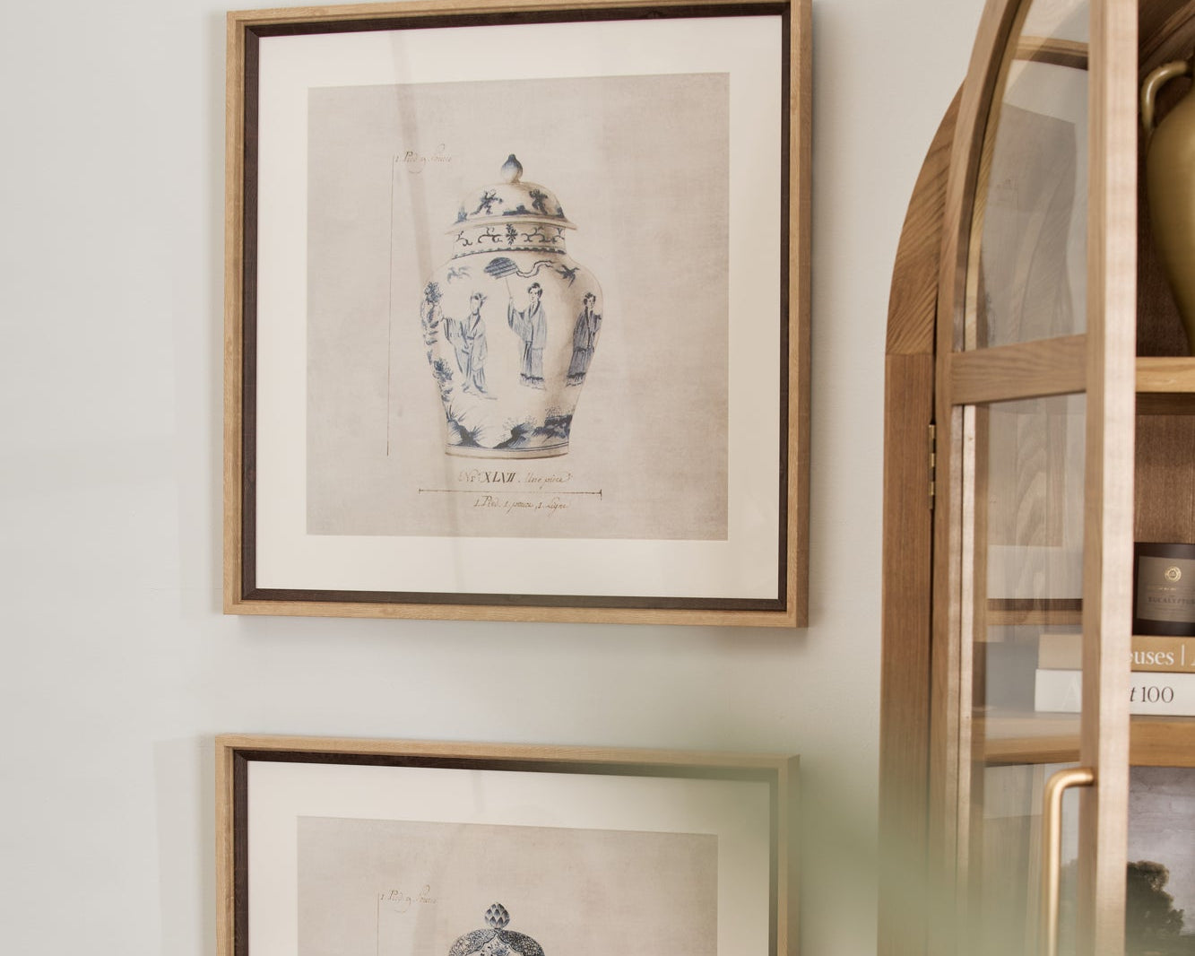 Two framed prints of chinoiserie urns hanging on a wall.