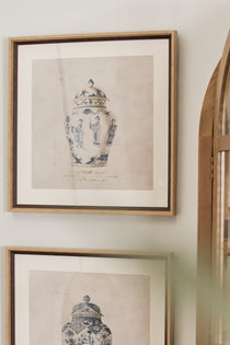 Two framed prints of chinoiserie urns hanging on a wall.