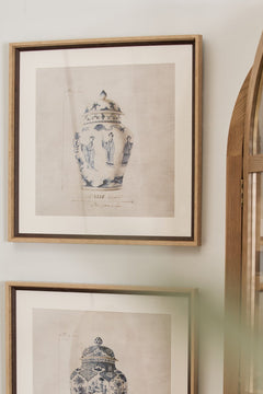 Two framed prints of chinoiserie urns hanging on a wall.