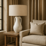 white ceramic Table Lamp with handles and Linen Shade sat on a side table next to a linen sofa
