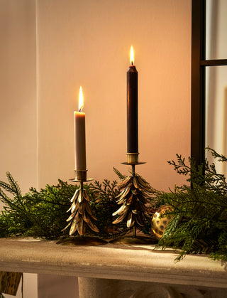 Set of two candleholders in a christmas tree design on a mantelpiece