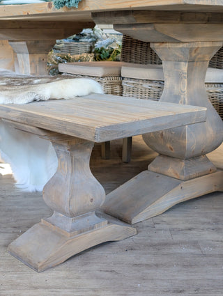 Wooden dining table with a rustic design on a wooden floor.