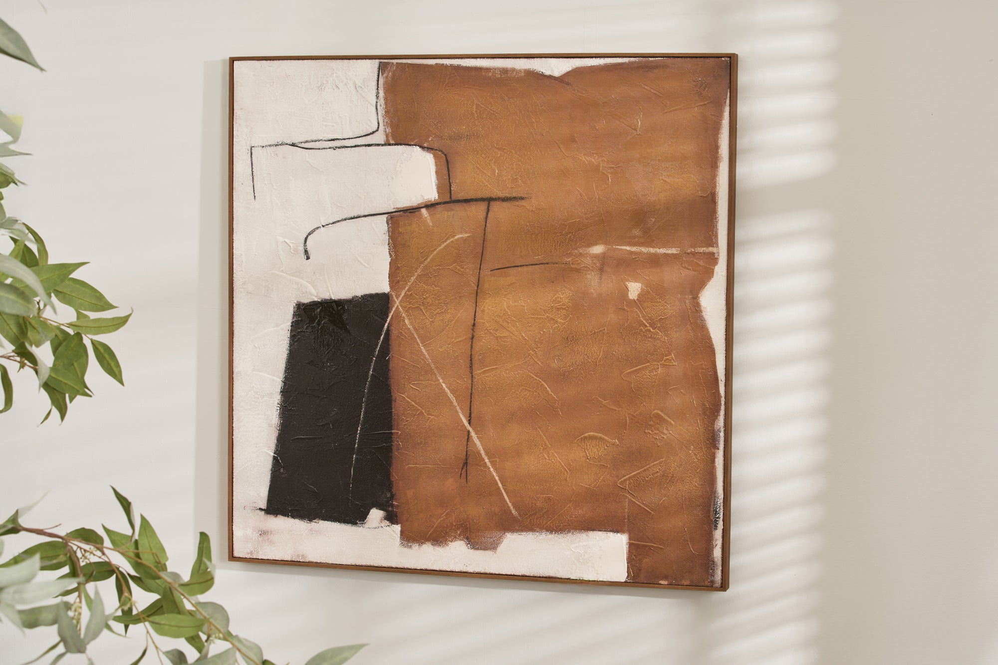 A neutral abstract canvas painting with tones of brown, black, and white, presented in a floating frame style, displayed on a wall.