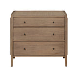 Natural wood 3-drawer dresser with rattan top, brass ring handles, and a warm Mindi veneer finish – ideal for boho or coastal bedrooms.