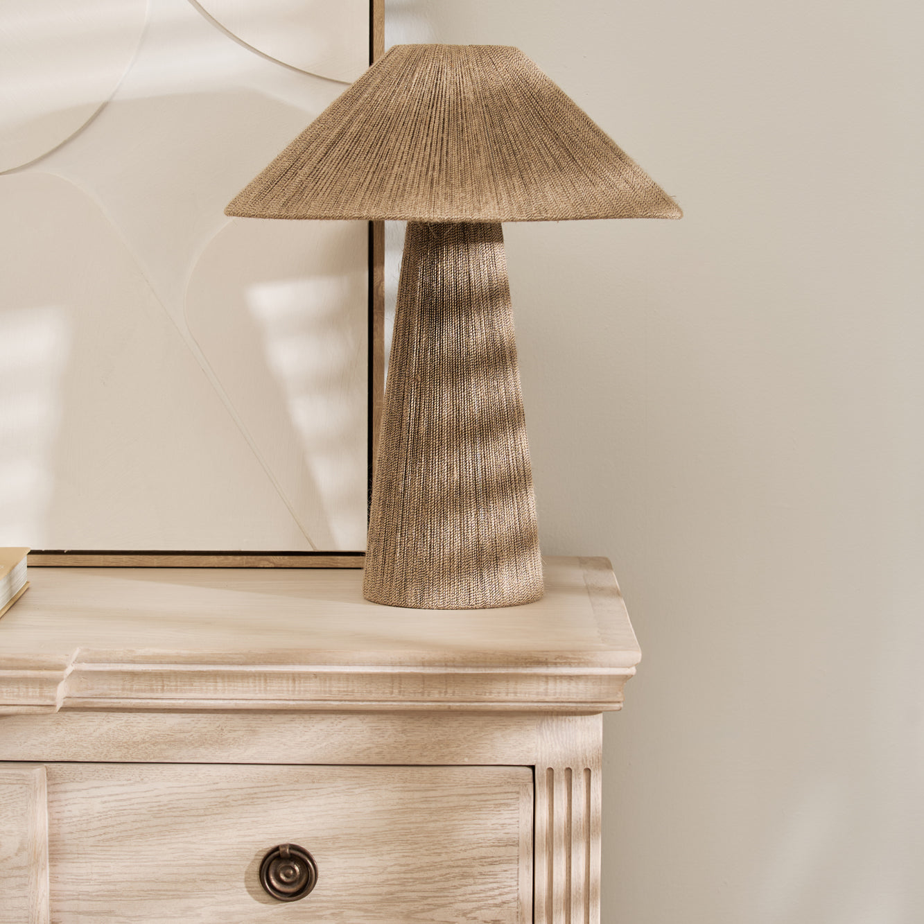 Natural jute table lamp with linen shade and tapered base on a wooden console