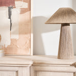 Natural jute table lamp with linen shade and tapered base on a wooden console