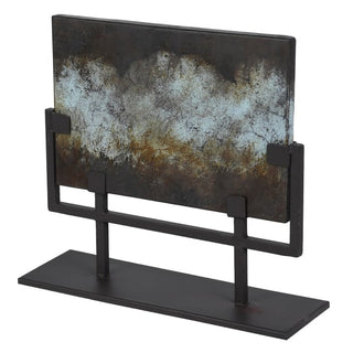 Verdigris iron plate on matt-black stand showing weathered blue-green and rust patina