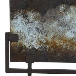 Close-up of verdigris iron plate showing layered patina and black iron stand bracket
