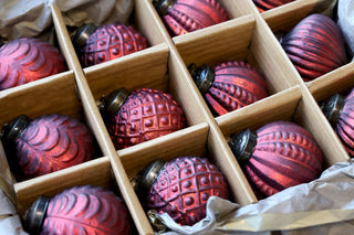 Assorted frosted red glass Christmas baubles with vintage-inspired patterns