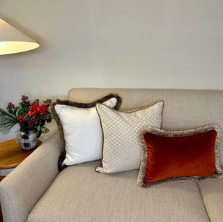 Naunton rust gold fringe rectangle cushion styled on a sofa