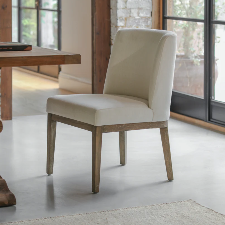 Natural linen dining chair with solid wood legs in a modern dining room setting