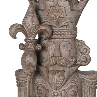 Close detail of the carved crown, moustache and fleur de lis sceptre on the wood effect nutcracker
