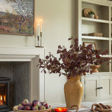 Living room with fireplace, decorative items, and a vase of flowers.