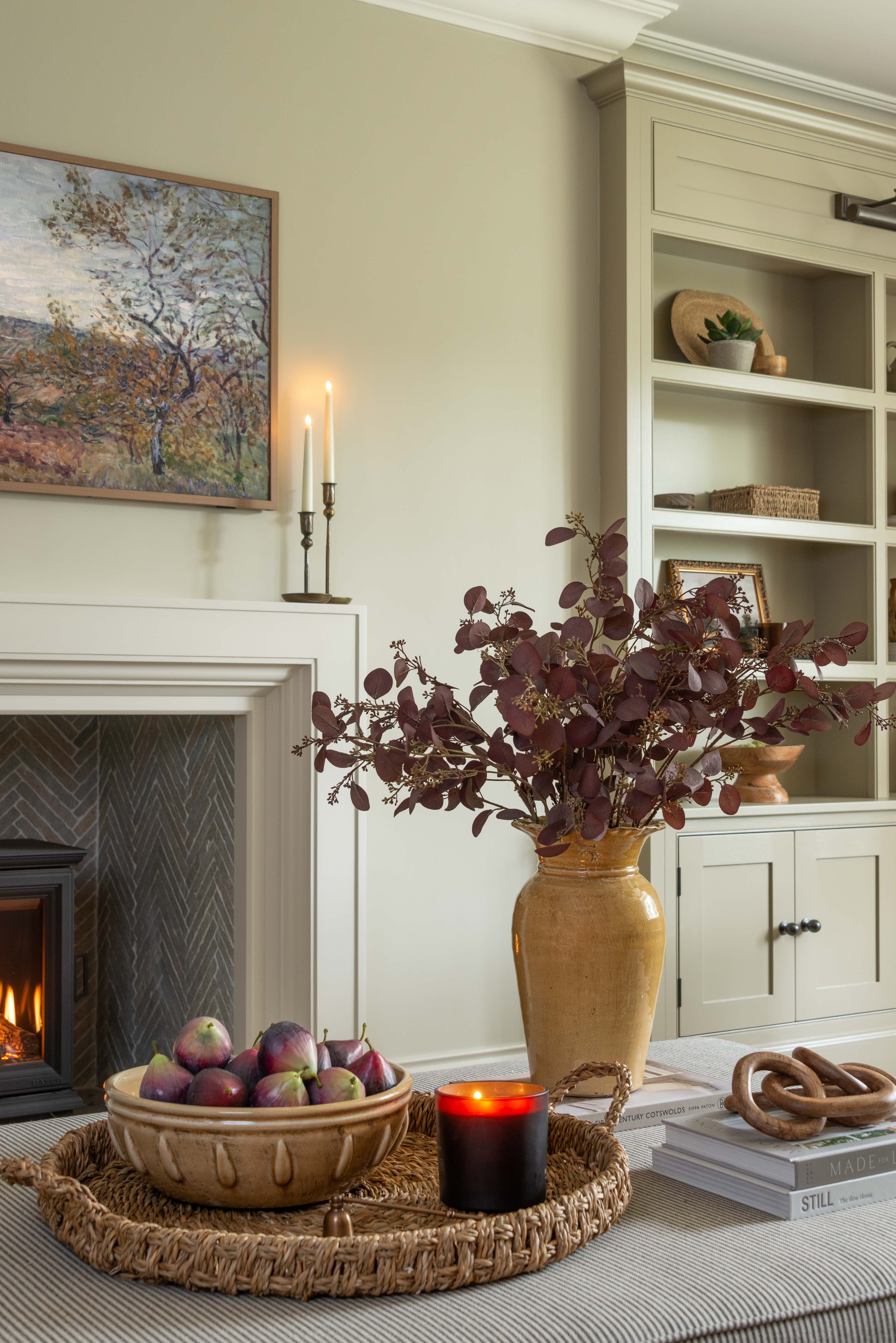 Living room with fireplace, decorative items, and a vase of flowers.