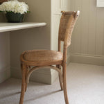 Exuding French-inspired elegance, this stunning open weave back chair is expertly crafted from premium rubber wood and rustic rattan.
