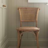 Exuding French-inspired elegance, this stunning open weave back chair is expertly crafted from premium rubber wood and rustic rattan.