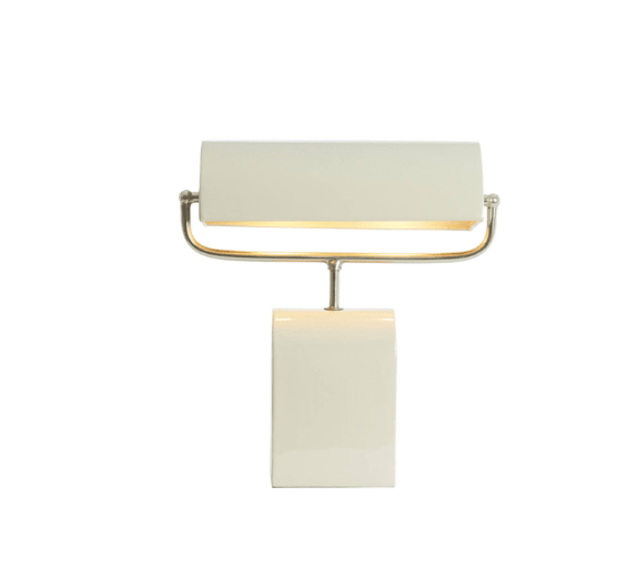 Oslo nickel dome table lamp lit on a travertine side table against panelled wall, warm focused glow