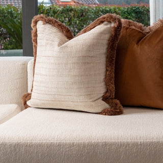Aldworth champagne cushion styled on a neutral sofa